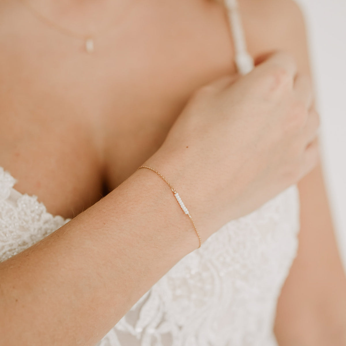 Brautarmband Belina aus 925 Sterlingsilber 18K vergoldet mit kleinen Perlen, mittig am Armband, am Model getragen in Nahaufnahme