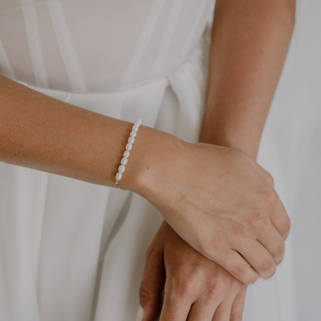 Braut Armband Linn aus 925 Sterlingsilber 18K vergoldet mit echten Süßwasserperlen, getragen von einem Model in Detailaufnahme