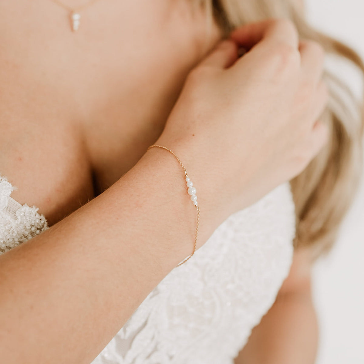 Brautarmband Mariella aus 925 Sterlingsilber 18K vergoldet mit kleinen veganen Perlen, am Model getragen in Nahaufnahme
