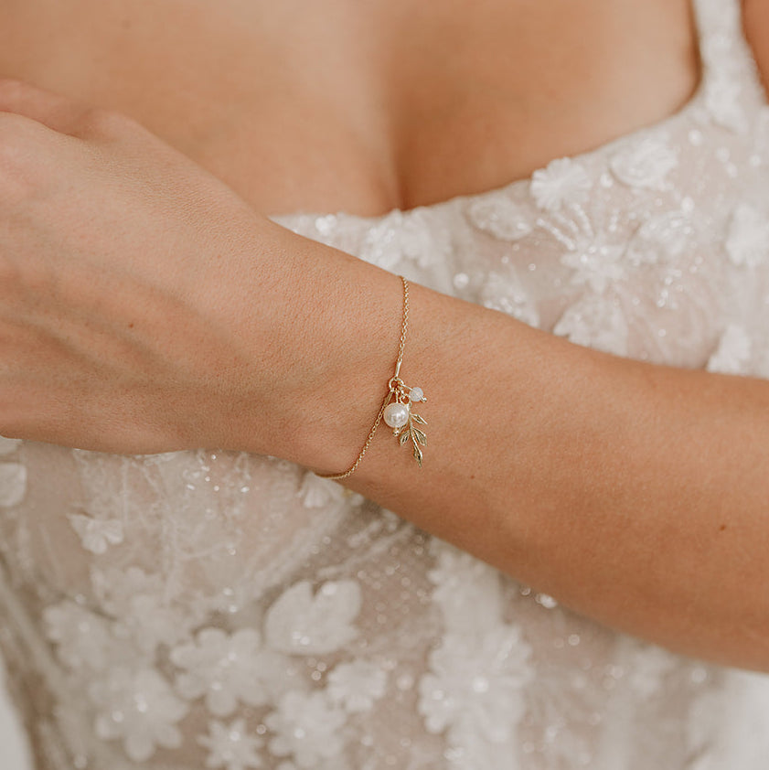 Schönes Brautarmband Resi aus 925 Sterlingsilber 18K vergoldet mit filigranen Blattanhängern, veganer Perle und White Opal Kristall, am Model getragen