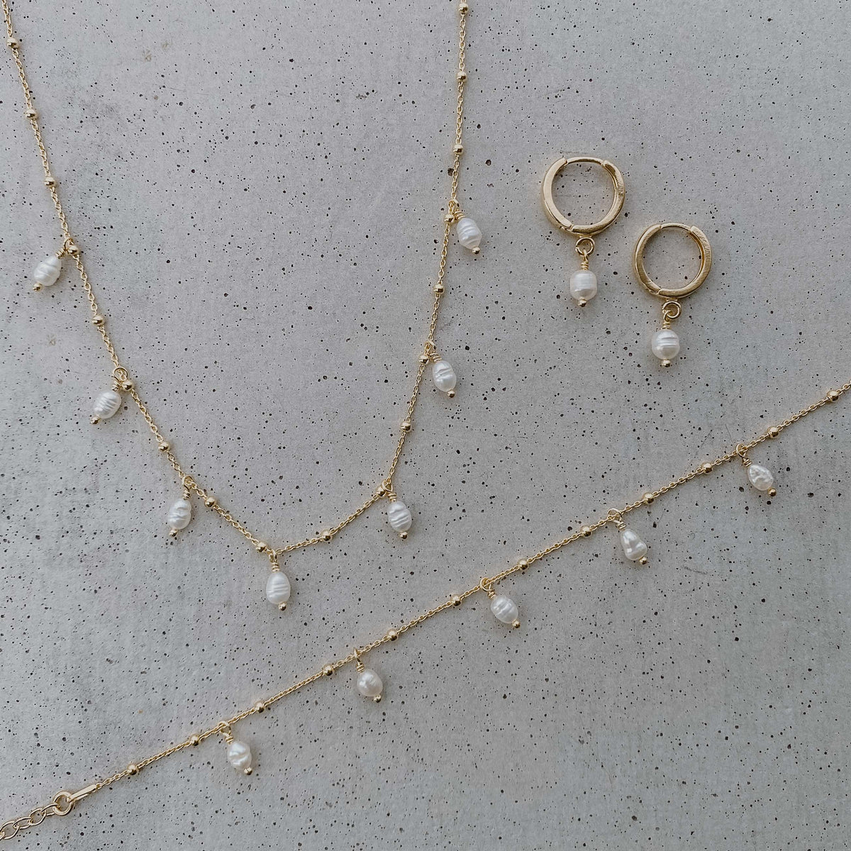 Braut Halskette Kaya aus 925 Sterlingsilber 18K vergoldet mit echten Süßwasserperlen mit passendem Braut Armband Kaya mit Süßwasserperlen und Braut Creolen Amelie, Nahaufnahme am Model getragen