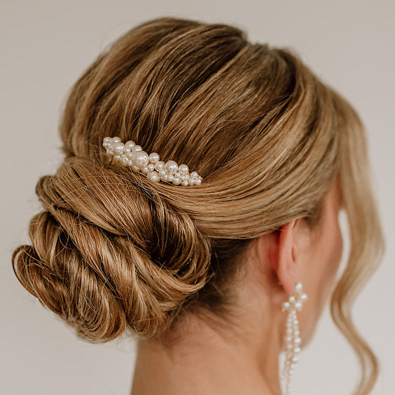 Braut Haarkamm Wilma in Gold mit unterschiedlich großen, veganen Perlen, getragen in einer eleganten Hochsteckfrisur