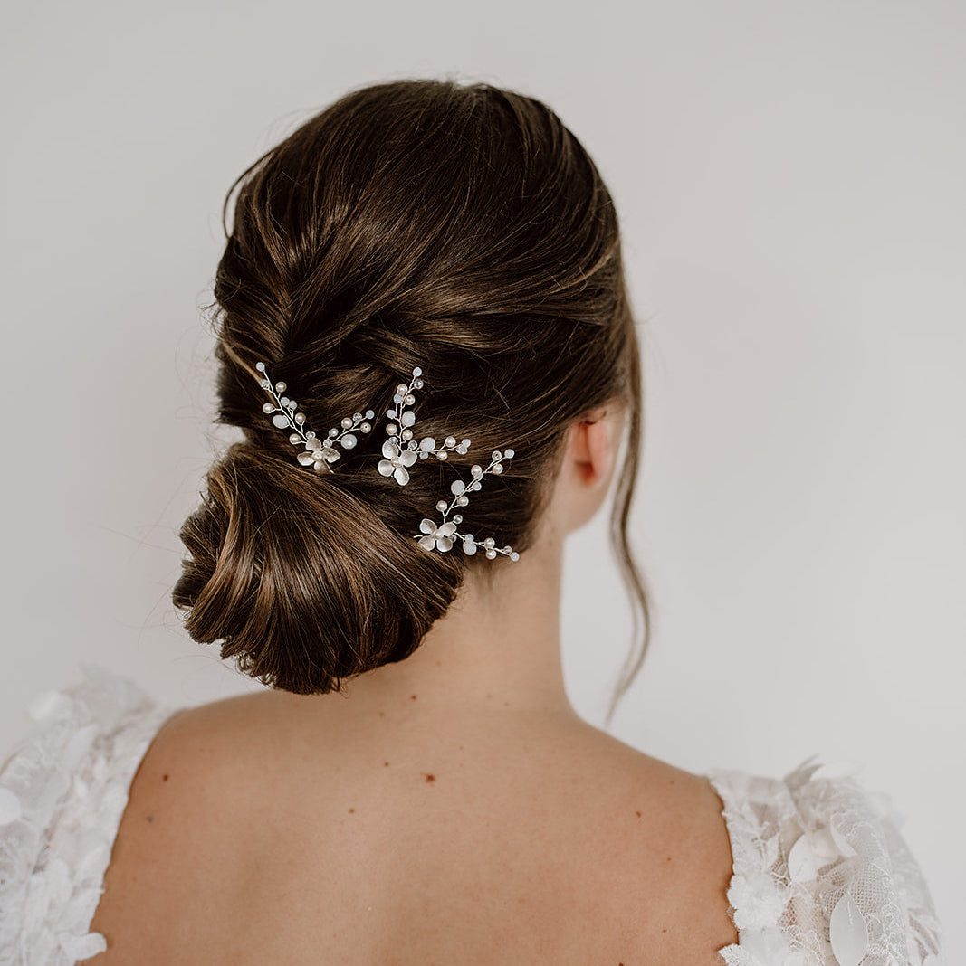 3er Set Braut Haarnadeln Babsi in Silber mit floralen Blüten, Kristallperlen und veganen Perlen, getragen in einer eleganten Hochsteckfrisur