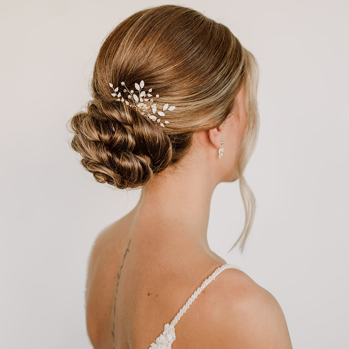 Braut Haarnadeln Gretchen in Gold mit ivoryfarbenen Blättern, white opal Kristallen in Blattform, veganen Perlen und Kristallperlen, zu sehen in einer eleganten Braut Hochsteckfrisur
