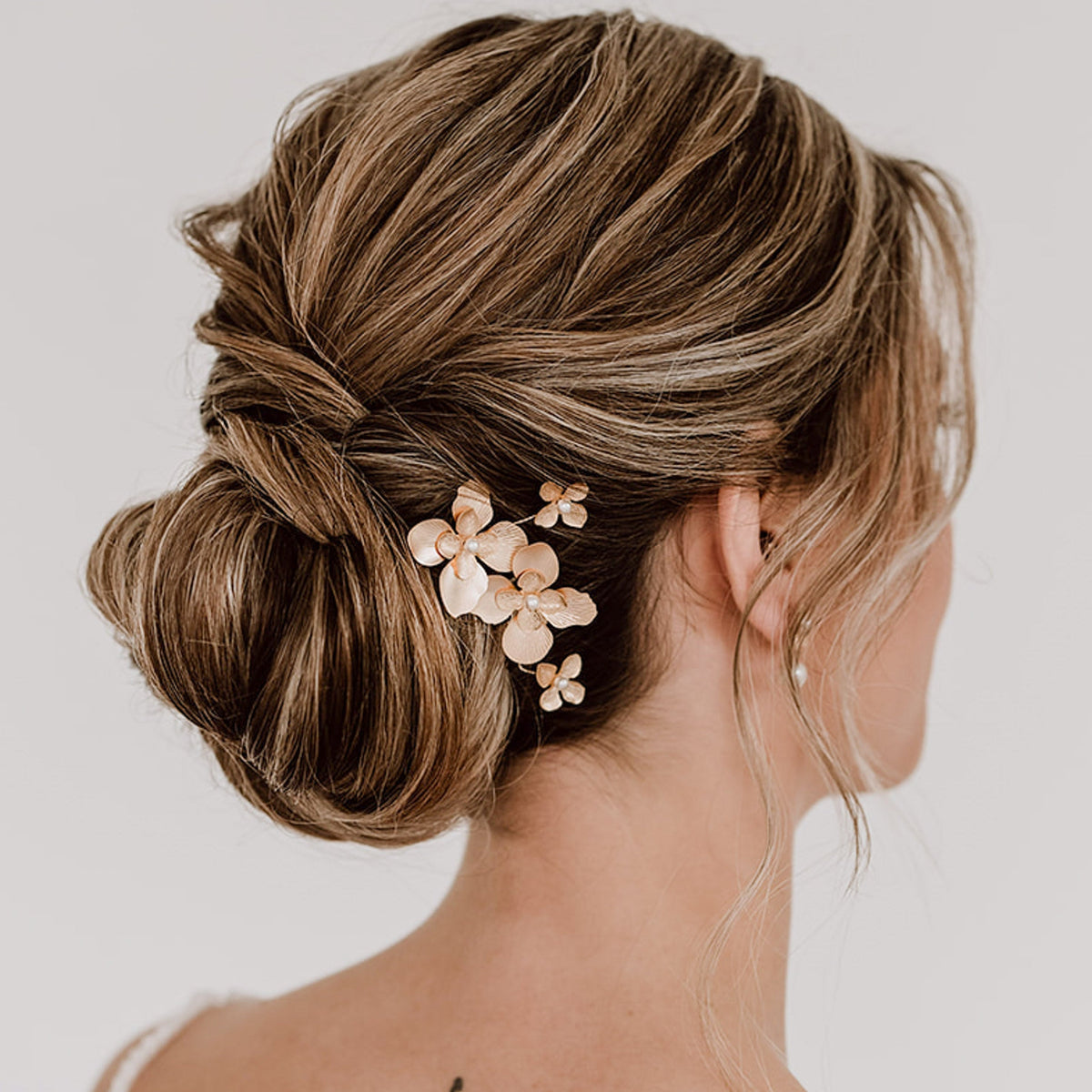 3er -Set Braut Haarnadeln Vika in Gold mit Blüten und Perlen, getragen in einer eleganten Hochsteckfrisur