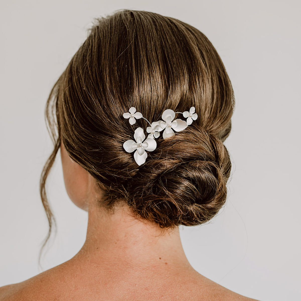 3er -Set Braut Haarnadeln Vika in Silber mit Blüten und Perlen, getragen in einer eleganten Hochsteckfrisur