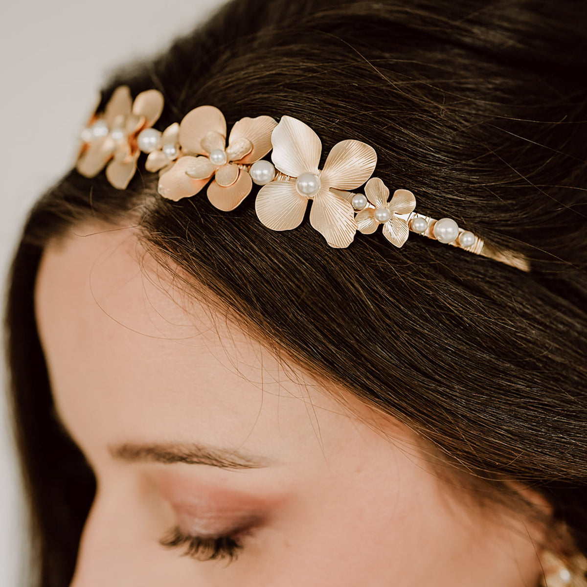 Braut Haarreif Vika in Gold mit Statement-Blüten und Perlen, am Model getragen in Nahaufnahme