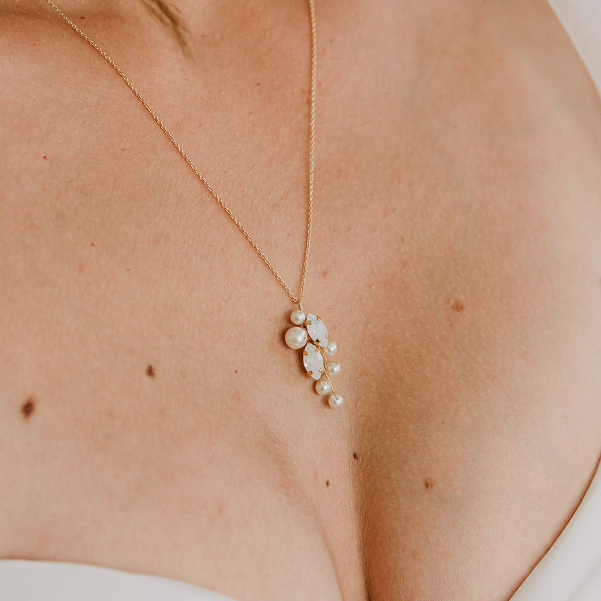 Brauthalskette Anastasia aus 925 Sterlingsilber 18K vergoldet mit veganen Perlen und blattförmigen white opal Kristallen, getragen vom Model in Nahaufnahme