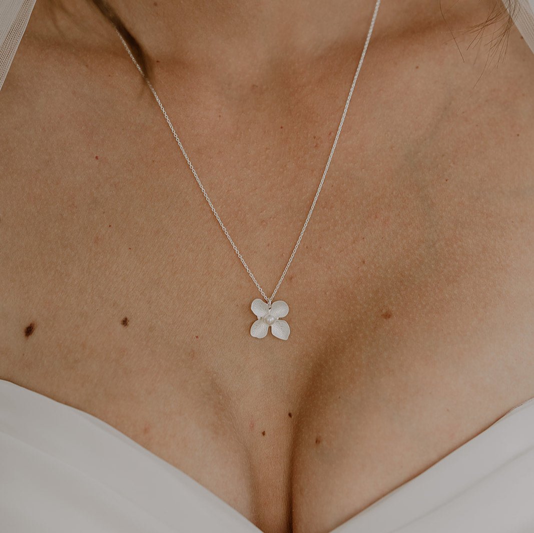 Braut Halskette Victoria aus 925 Sterlingsilber mit Blüte und veganer Perle, Nahaufnahme am Model getragen