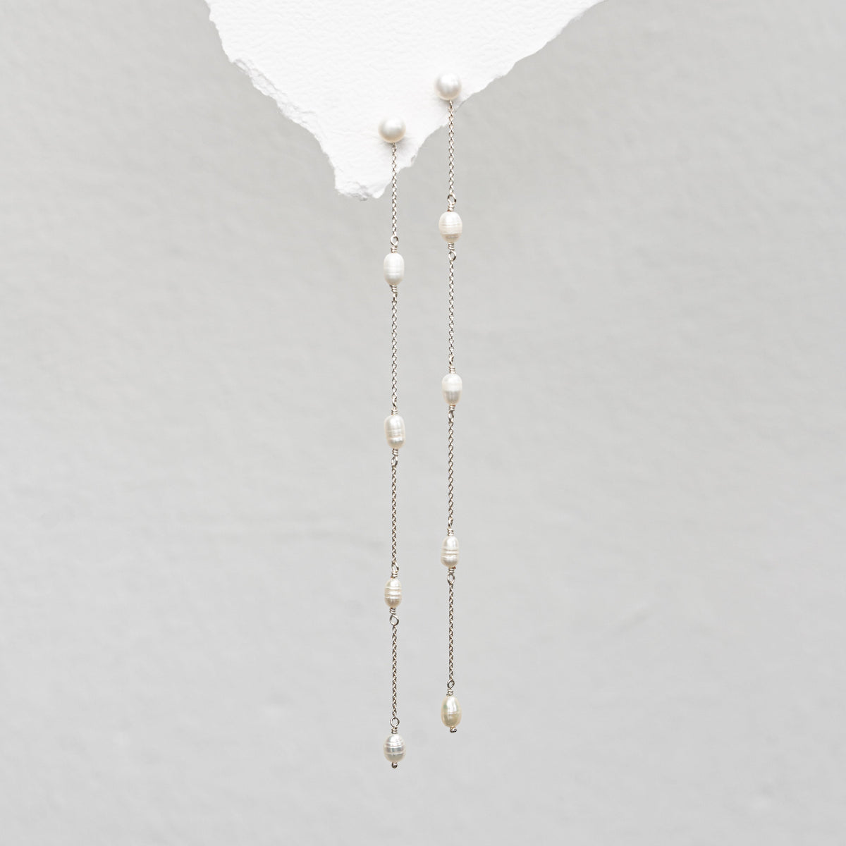 Braut Ohrringe Maeve lang aus 925 Sterlingsilber, Perlenstecker mit Süßwasserperlen und zarten Kettchen, in Nahaufnahme