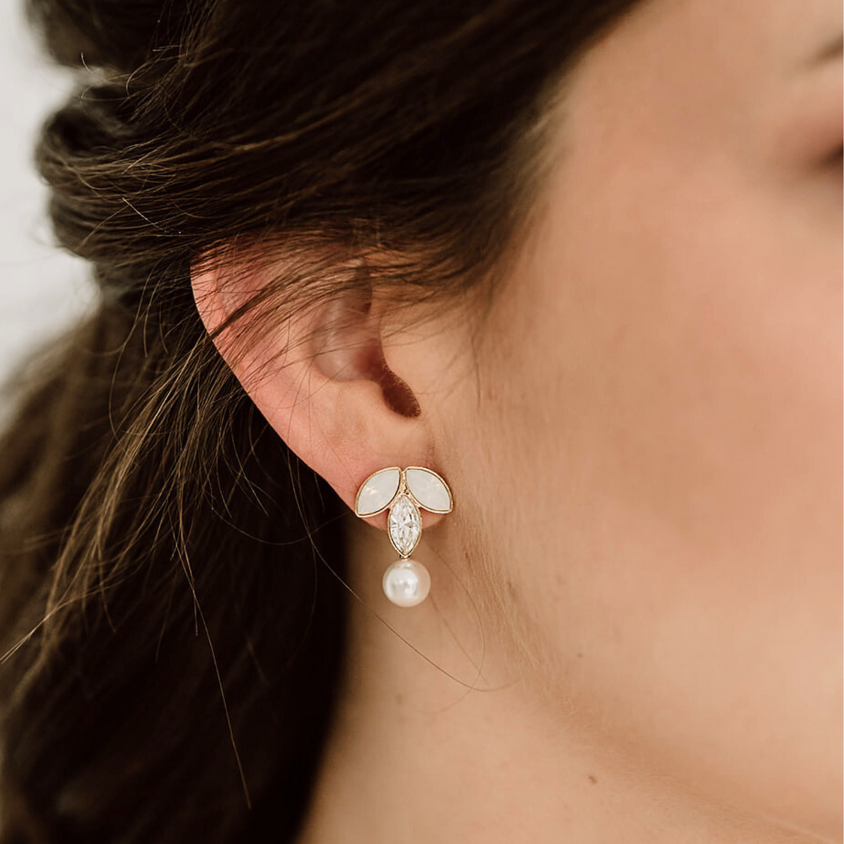 Brautohrringe Katy aus 925 Sterlingsilber 18K vergoldet mit white opal und crystal Kristallen in Blattform und veganer Perle, am Model getragen in Nahaufnahme