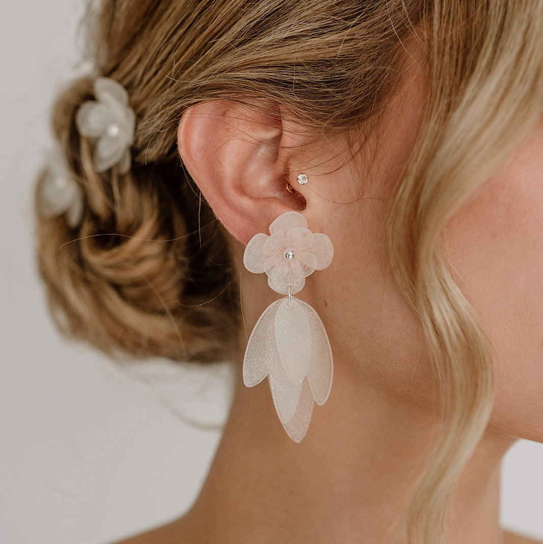 Statement Brautohrringe Chiara mit weißen Blüten aus biobasiertem, nachhaltigen Material, aus 925 Sterlingsilber, am Model getragen