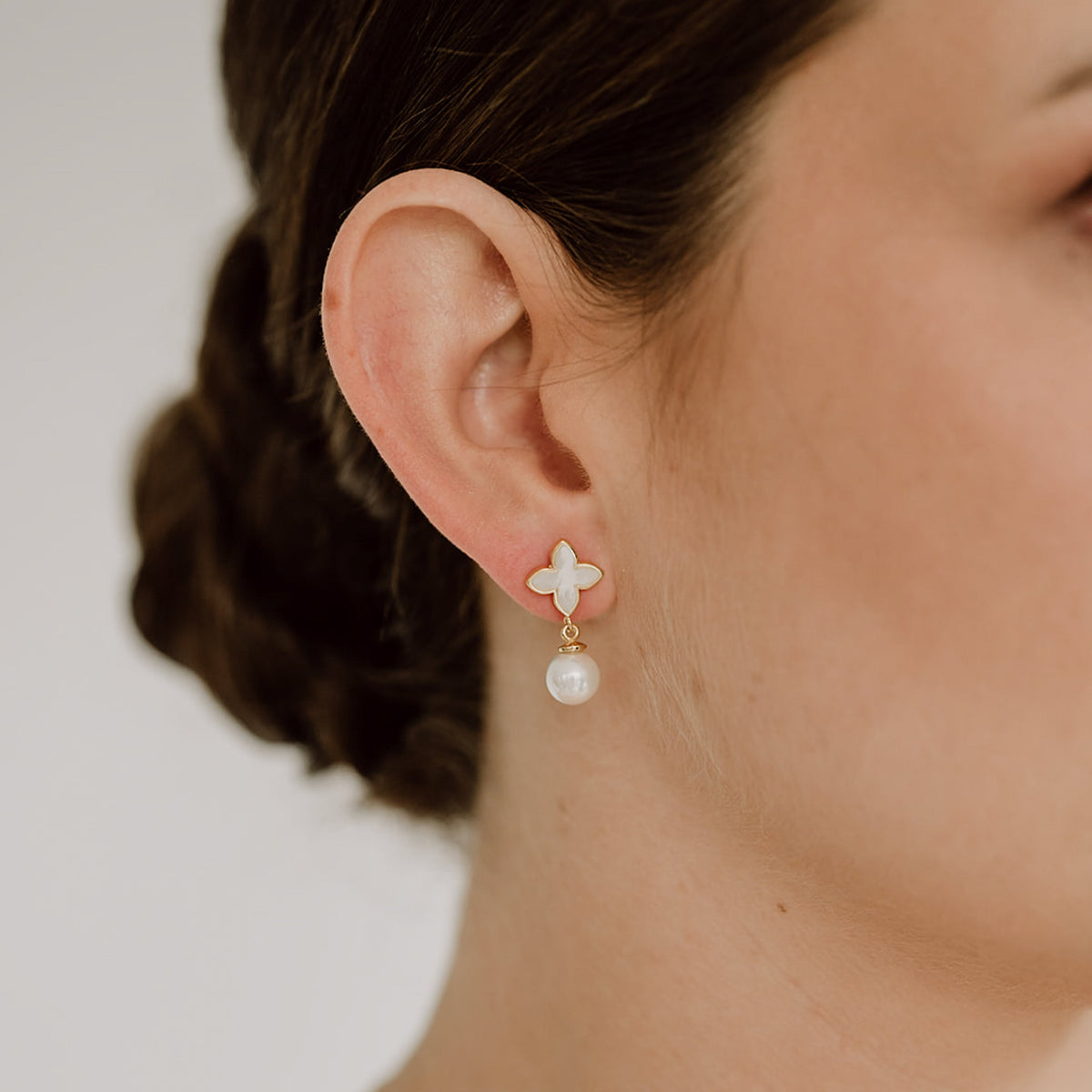 Braut Ohrringe Daisy mit Perle aus 925 Sterlingsilber 18K vergoldet mit perlmuttfarbener Blüte und veganer Perle, am Model getragen in Nahaufnahme