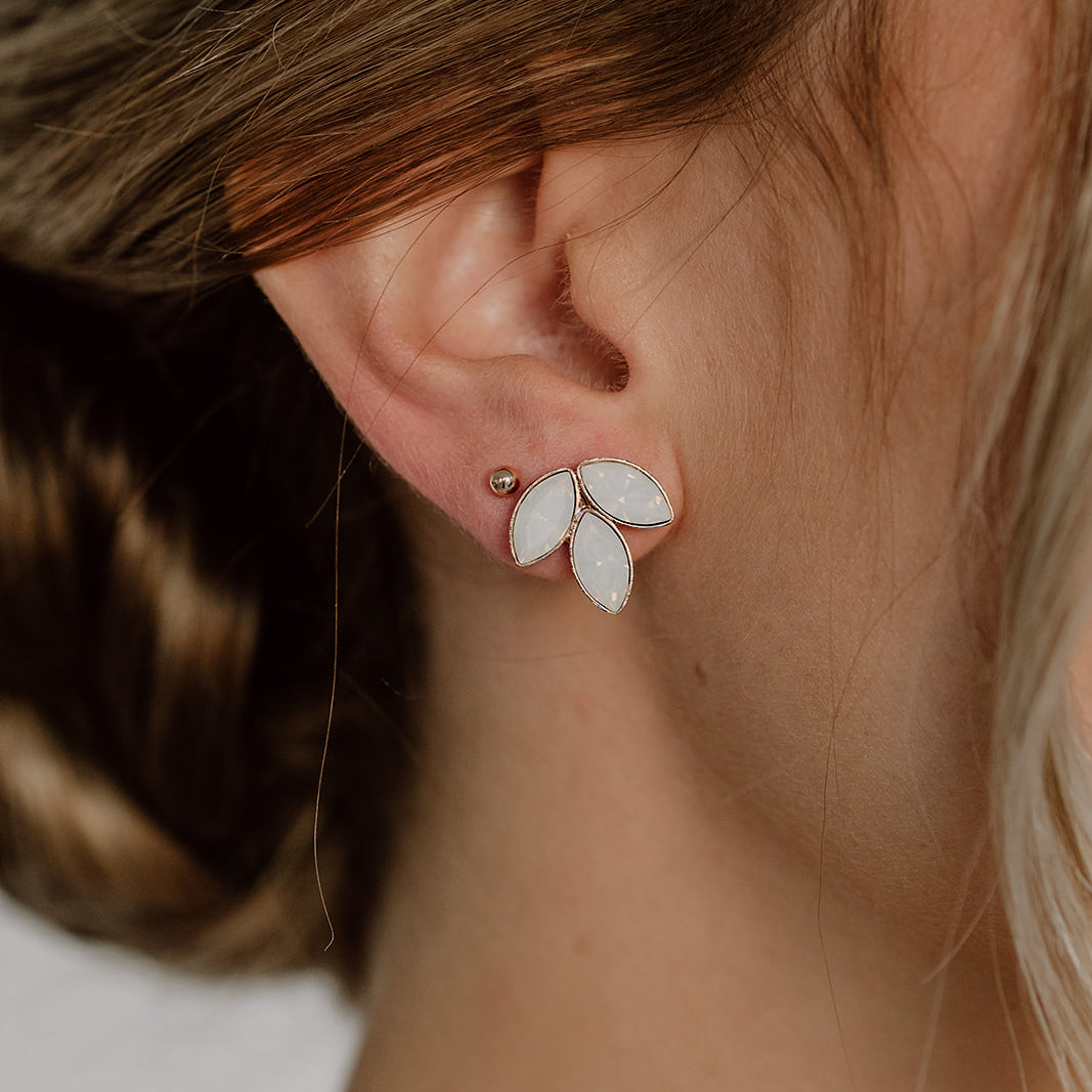Detailaufnahme der Brautohrstecker Kate mit funkelnden white opal Kristallen aus 925 Sterlingsilber 18K rosévergoldet, von einer Braut getragen