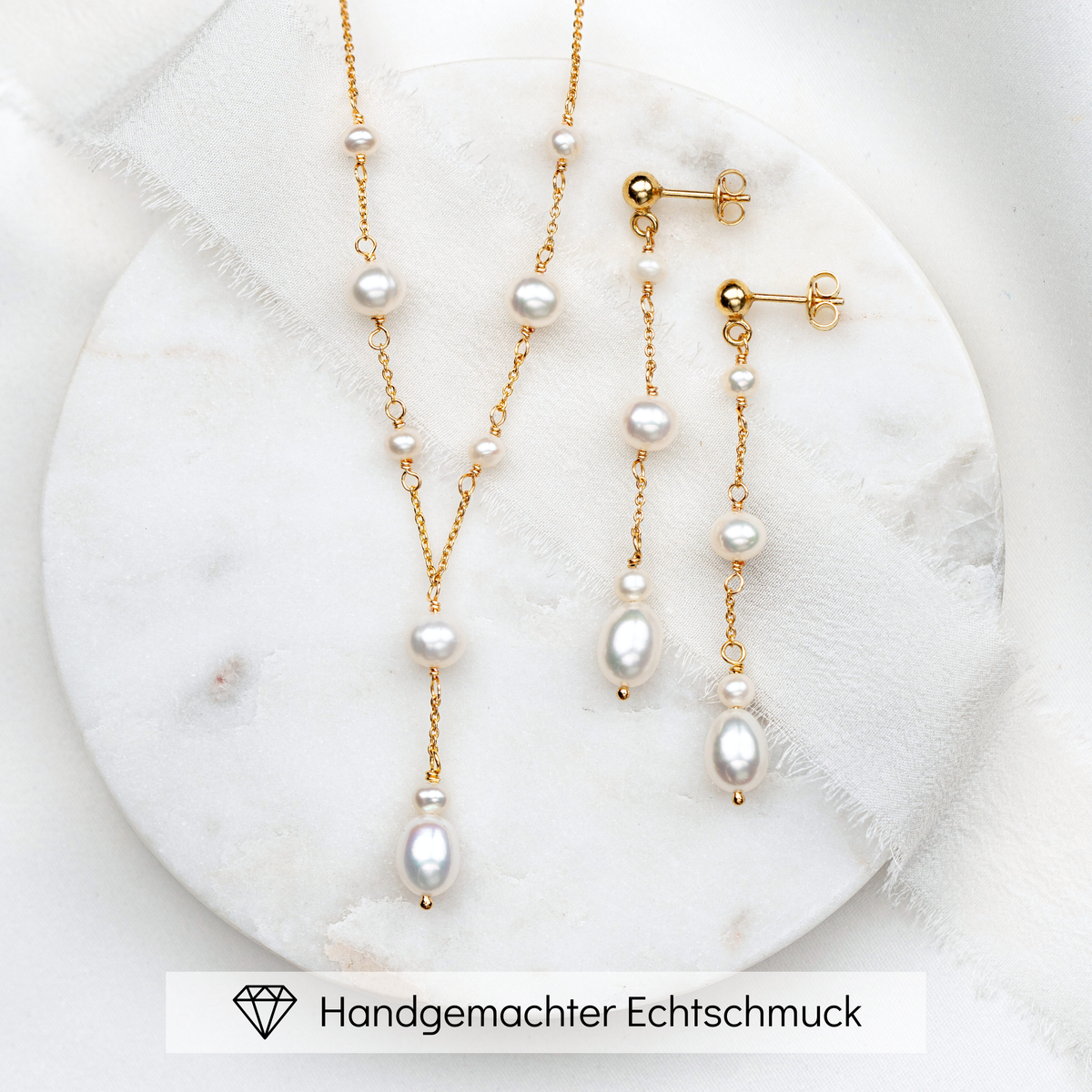 2-teiliges Brautschmuckset Joy aus 925 Sterlingsilber 18K vergoldet – Y-Halskette und hängende Ohrringe mit echten, unterschiedlich großen Süßwasserperlen, auf Marmorplatte