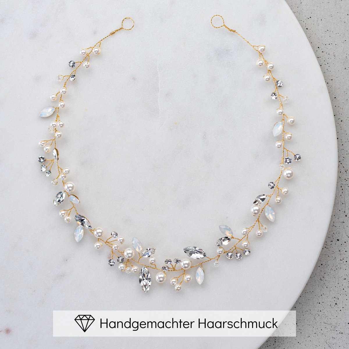 Braut Headpiece Luise in Gold mit Perlen und Kristallen, liegend auf einer Marmorplatte