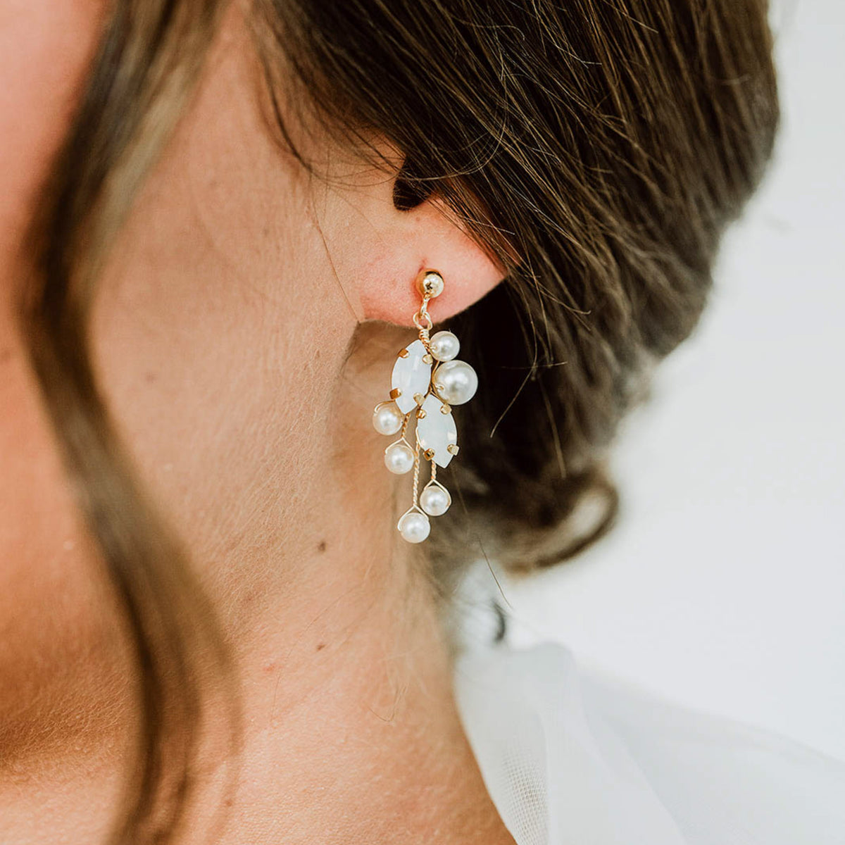 Ohrringe Ana 925 Sterlingsilber 18K vergoldet mit white opal Kristallen und veganen Perlen, getragen am Model