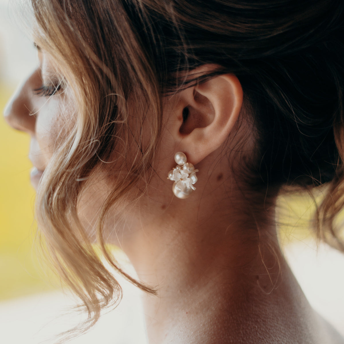 Braut Ohrringe Sofie in 925 Sterlingsilber 18K vergoldet mit unterschiedlich großen, veganen Perlen und Blüten, Nahaufnahme am Ohr