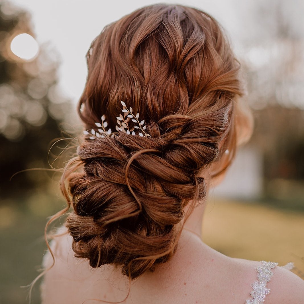 Braut Haarnadeln Lana mit floralen ivoryfarbenen Blättern, von einer Braut im hochgesteckten Haar getragen