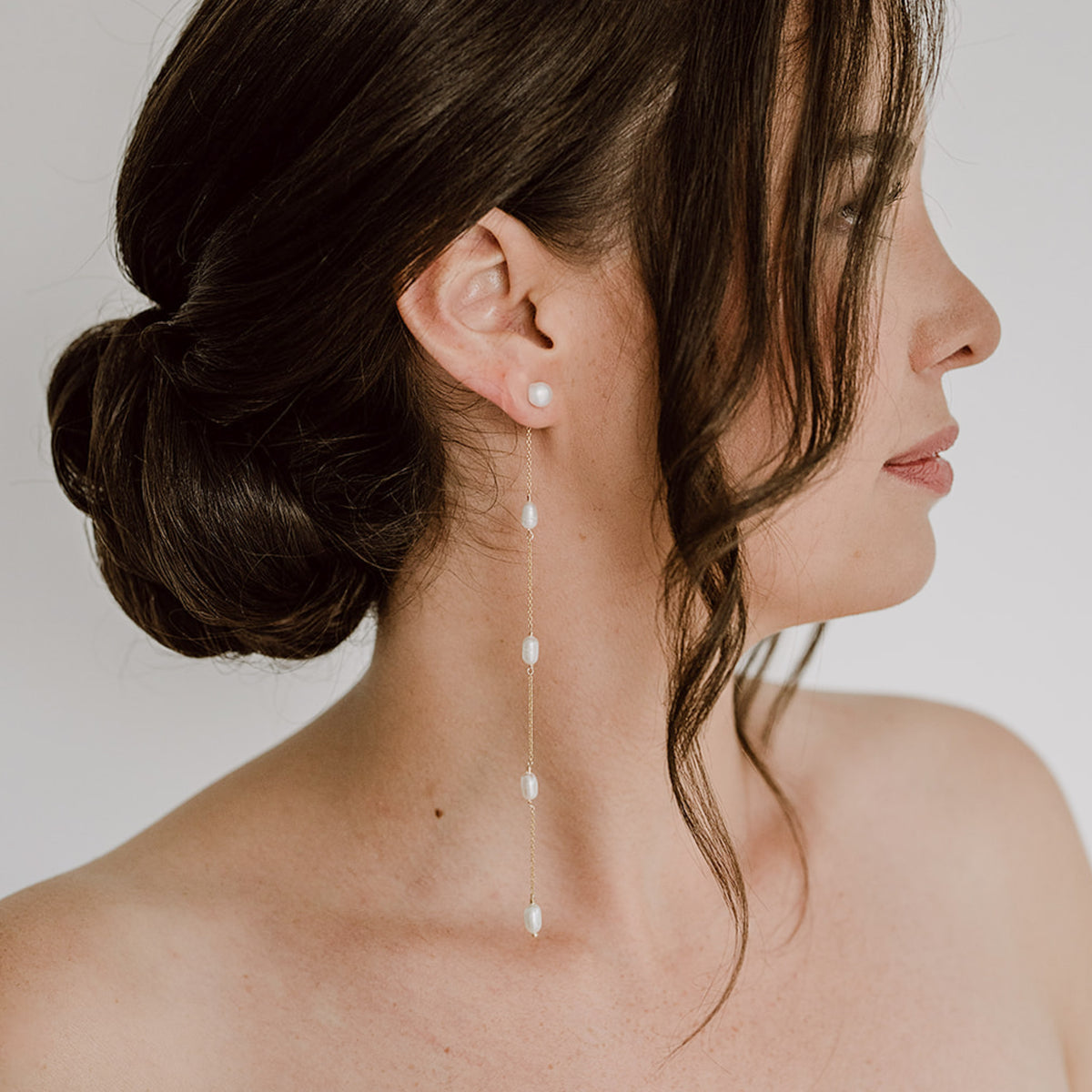 Braut Ohrringe Maeve lang aus 925 Sterlingsilber 18K vergoldet, Perlenstecker mit Süßwasserperlen und zarten Kettchen, am Model getragen in Nahaufnahme