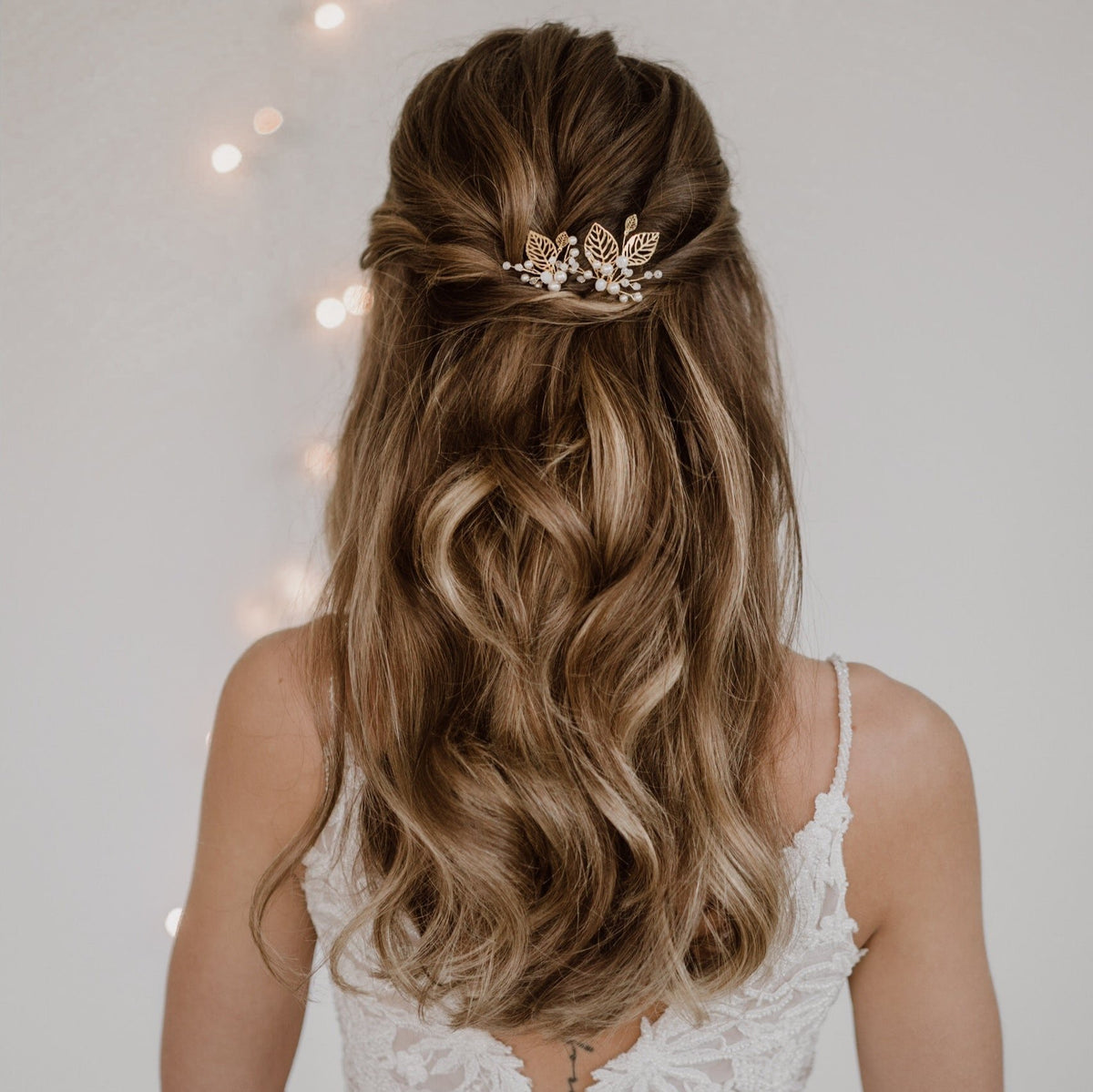 2er Set Braut Haarnadeln Zoe in Gold mit filigranen Blättern, veganen Perlen und white opal Kristallperlen, getragen vom Model in einer halboffenen Brautfrisur