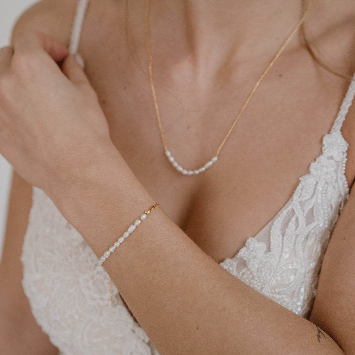 Braut Armband Linn aus 925 Sterlingsilber 18K vergoldet mit echten Süßwasserperlen, getragen von einem Model in Detailaufnahme