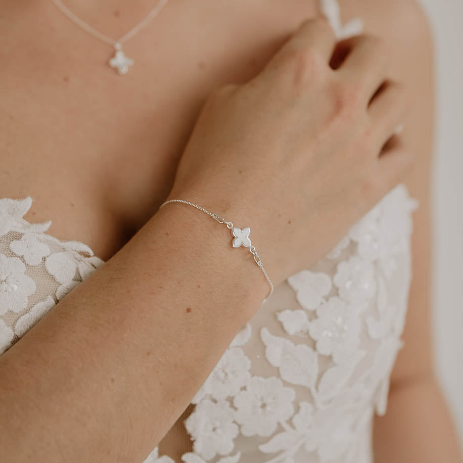 Brautarmband Daisy aus 925 Sterlingsilber mit kleiner perlmuttfarbener Blüte, am Model getragen in Nahaufnahme