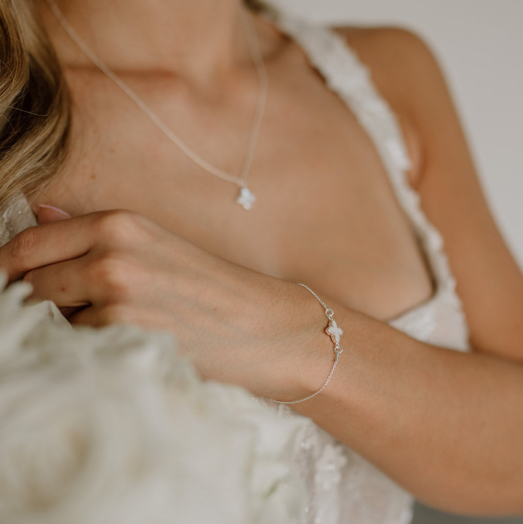 Brautarmband Daisy aus 925 Sterlingsilber mit kleiner perlmuttfarbener Blüte, am Model getragen