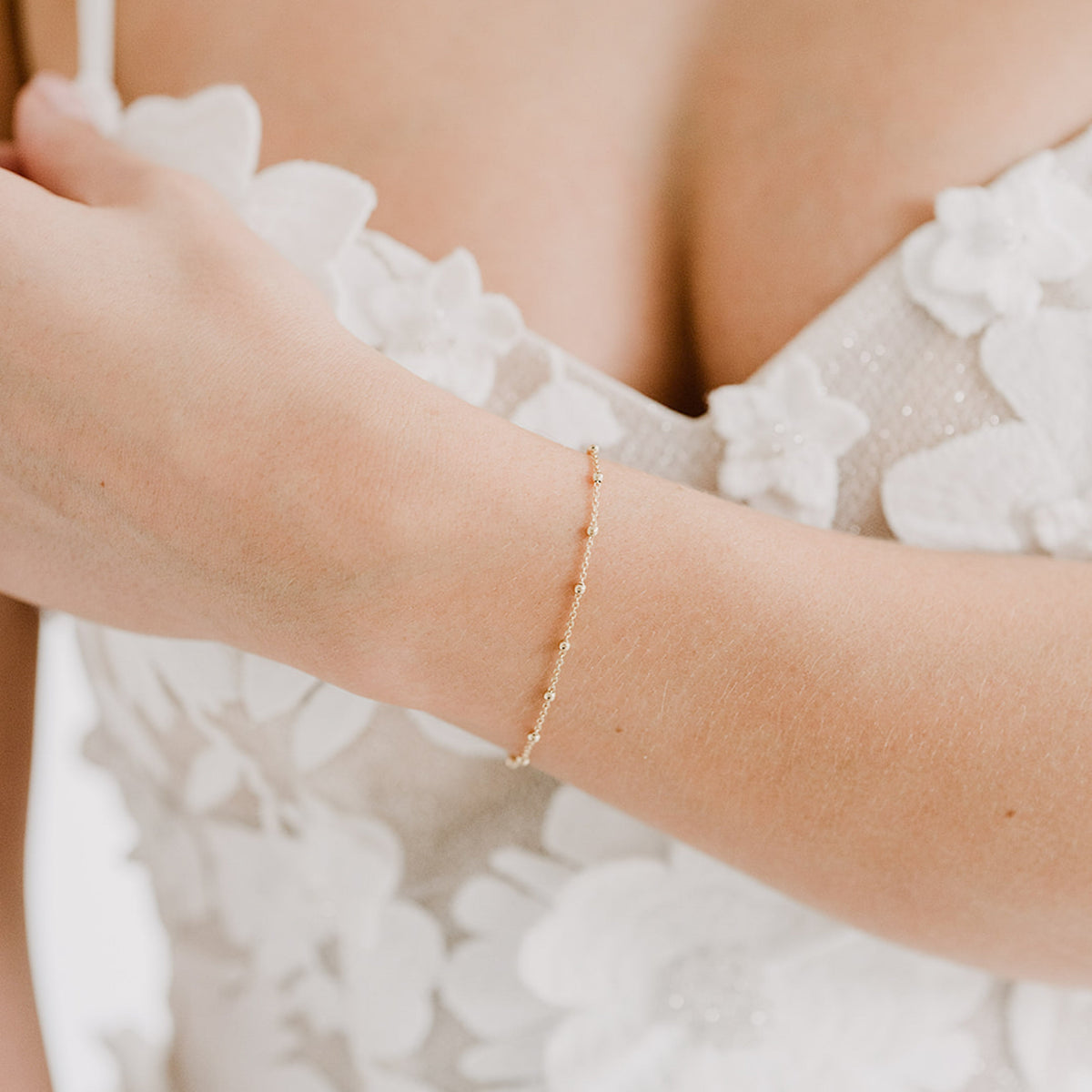 Dezentes Brautarmband Kaya aus 925 Sterlingsilber 18K vergoldet mit kleinen Kugeln, am Model getragen in Nahaufnahme