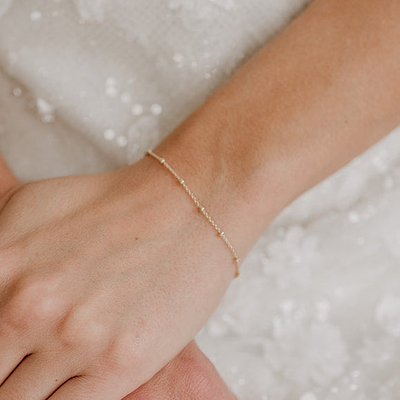 Dezentes Brautarmband Kaya aus 925 Sterlingsilber 18K vergoldet mit kleinen Kugeln, am Model getragen in Nahaufnahme