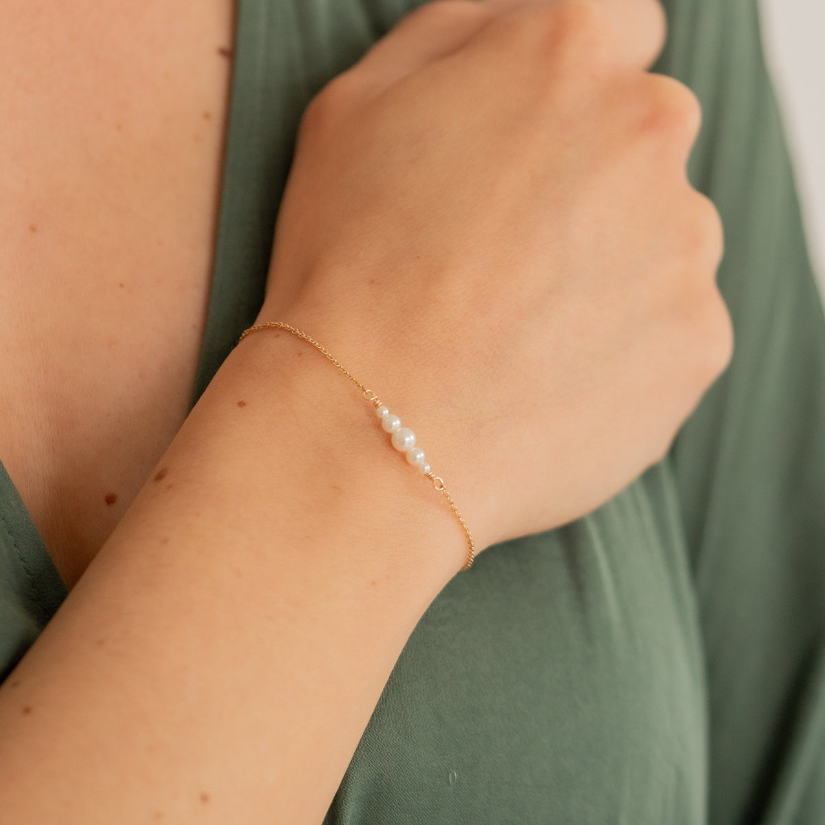 Trauzeugin Armband Mariella aus 925 Sterlingsilber 18K vergoldet mit kleinen veganen Perlen, am Model getragen in Nahaufnahme