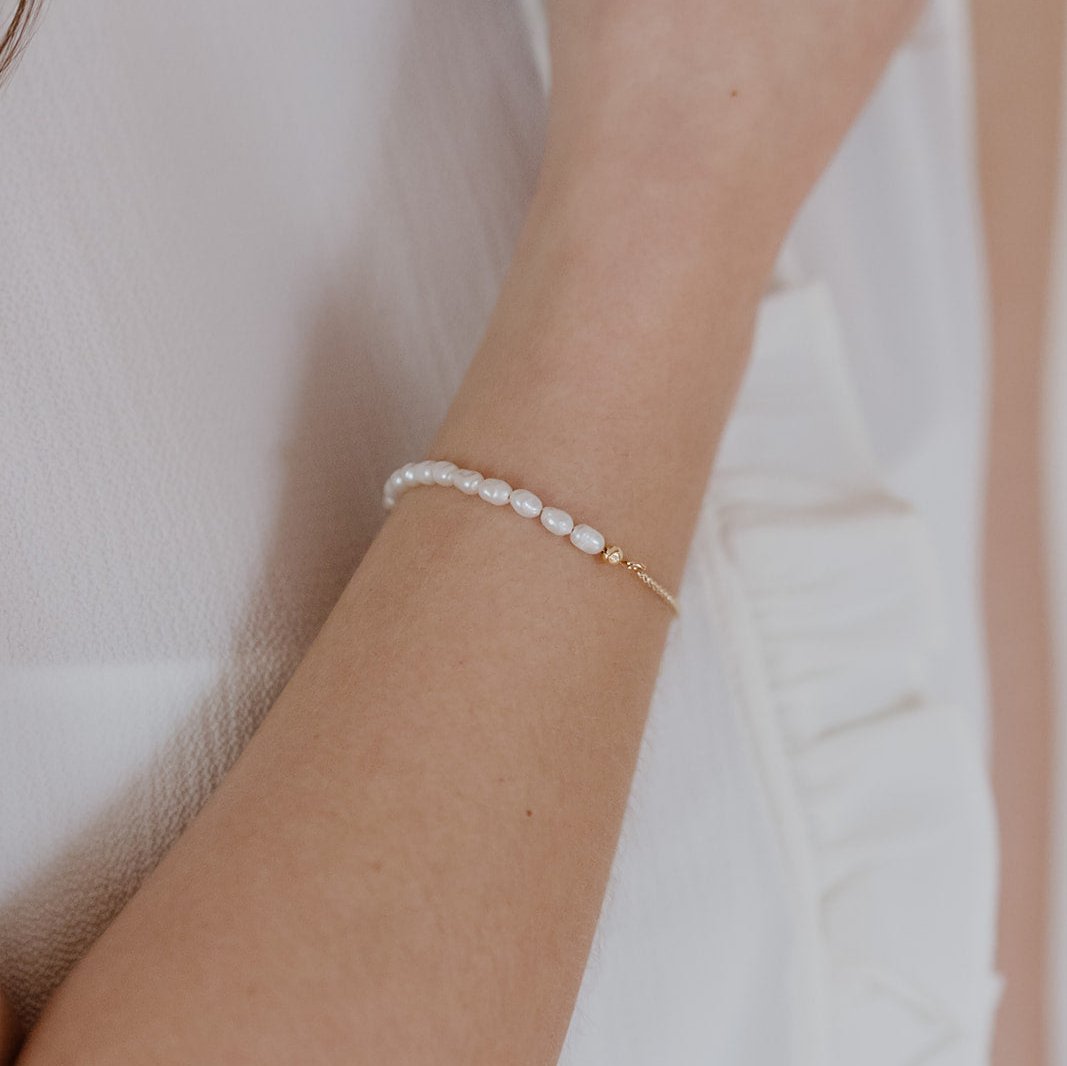 Braut Armband Linn aus 925 Sterlingsilber 18K vergoldet mit echten Süßwasserperlen, getragen von einem Model in Detailaufnahme
