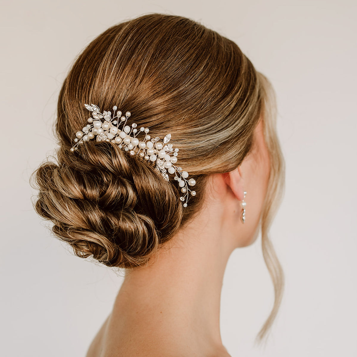 Braut Haarkamm Kris in Silber mit blattförmigen crystal Kristallen, Kristallperlen, veganen Perlen und Süßwasserperlen, getragen in einer eleganten Braut Hochsteckfrisur
