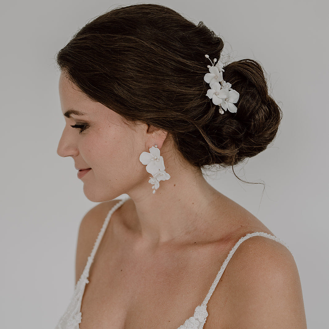 Braut Haarnadeln Coco in Silber mit weißen Porzellanblüten und echten Süßwasserperlen mit passenden Ohrringen Coco, getragen in einer eleganten Hochsteckfrisur