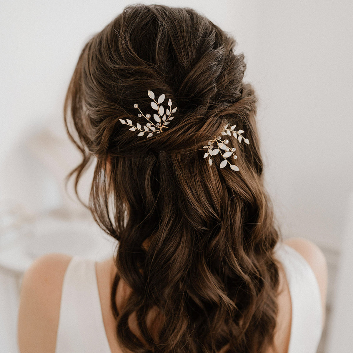 Braut Haarnadeln Gretchen in Gold mit ivoryfarbenen Blättern, white opal Kristallen in Blattform, veganen Perlen und Kristallperlen, zu sehen in einer Brautfrisur mit halb offenem Haar