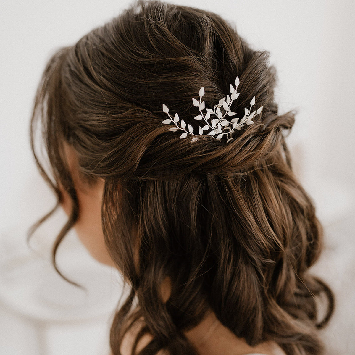 Schöne Braut Haarnadeln Lana in Silber – florales 3er Set mit ivoryfarbenen Blättern, getragen in einer halboffenen Brautfrisur
