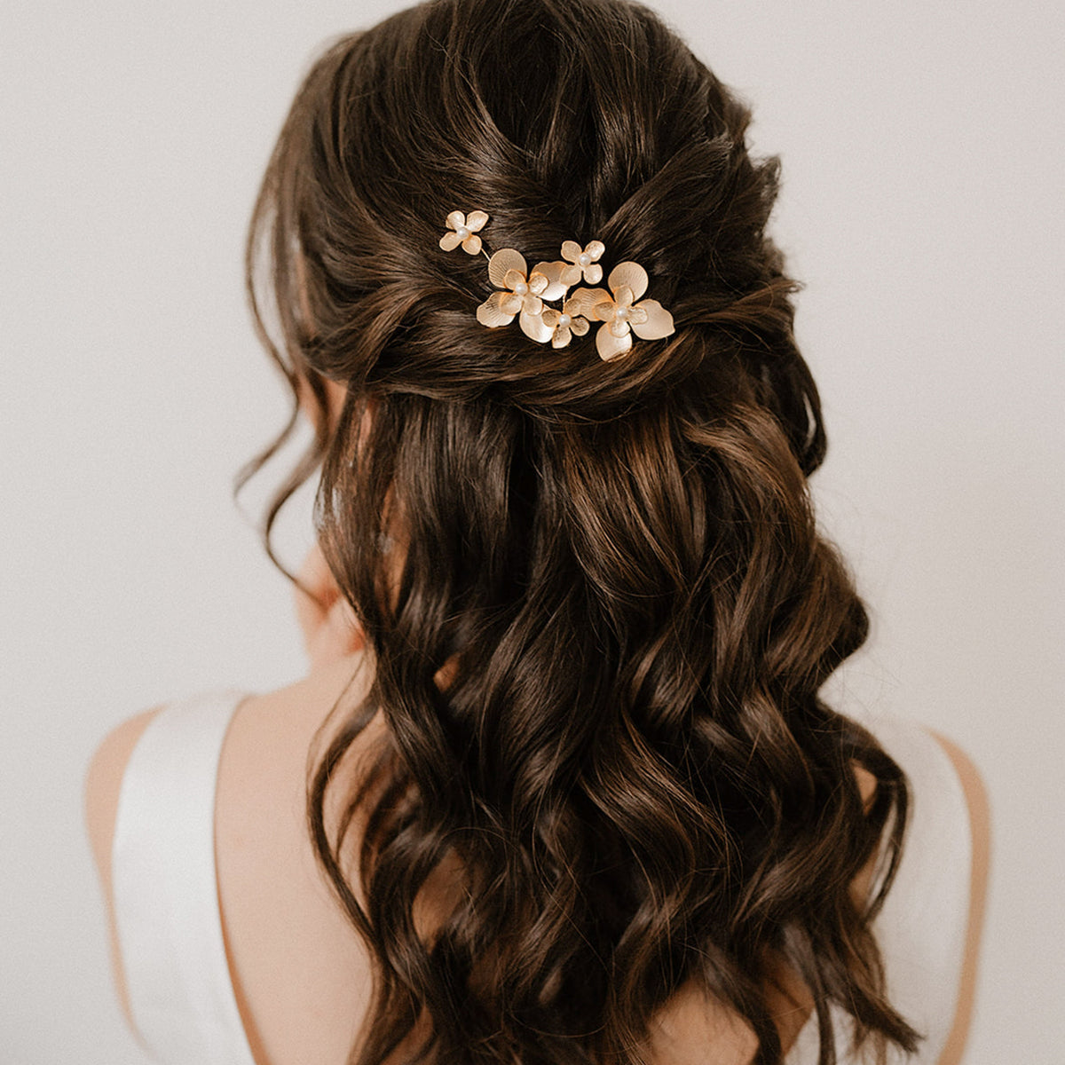 3er -Set Braut Haarnadeln Vika in Gold mit Blüten und Perlen, getragen in einer eleganten halboffenen Brautfrisur