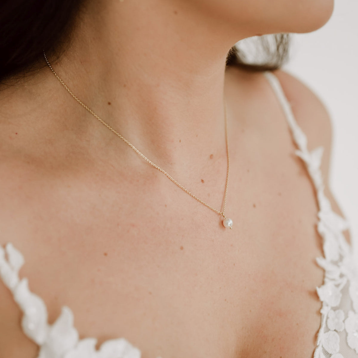 Schlichte Braut Perlenkette Perla aus 925 Sterlingsilber 18K vergoldet mit kleiner veganer Perle 6mm, auf Marmorplatte