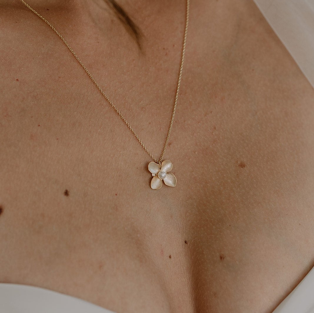 Braut Halskette Victoria aus 925 Sterlingsilber 18K vergoldet mit Blüte und veganer Perle, Nahaufnahme am Model getragen