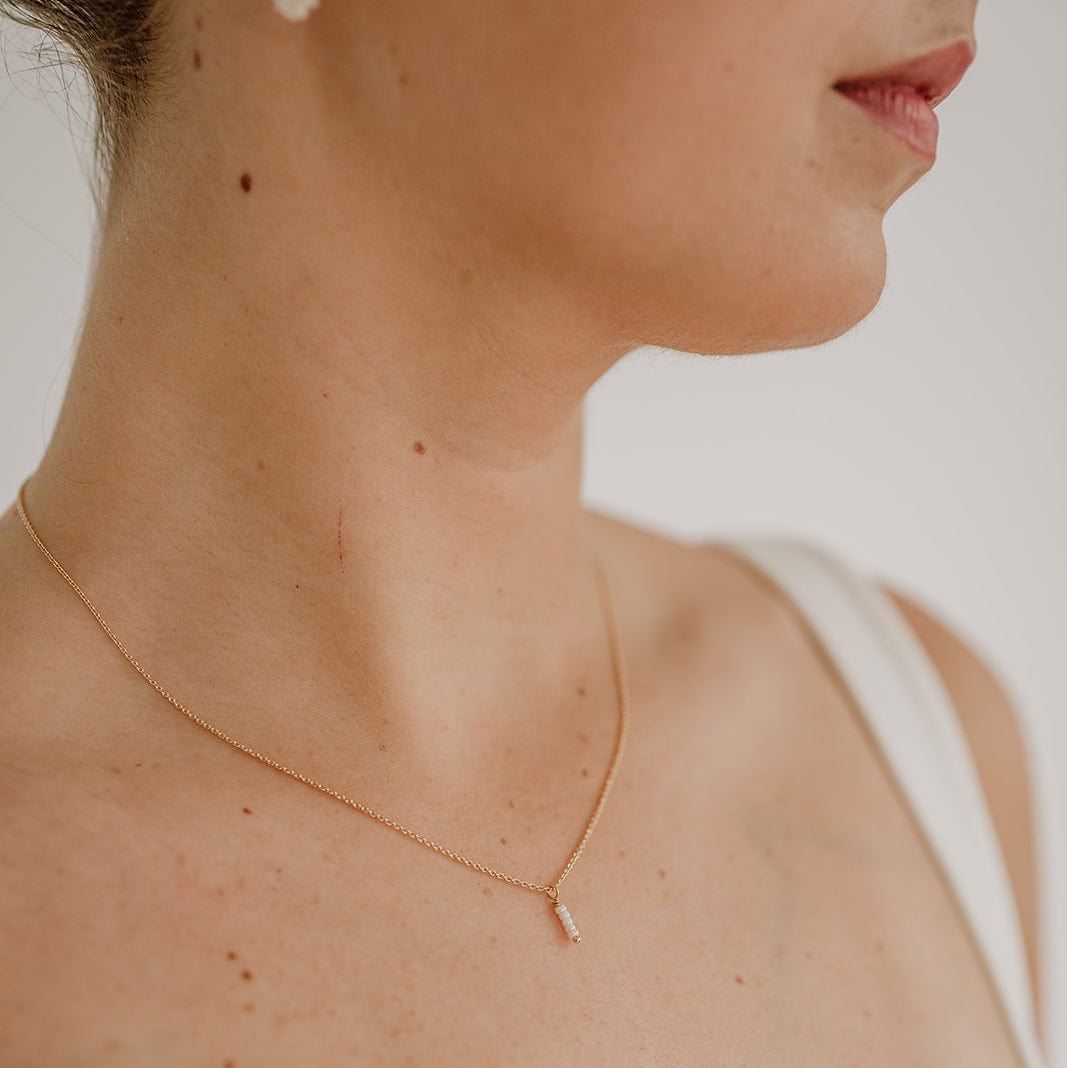 Braut Y-Kette Belina aus 925 Sterlingsilber 18K vergoldet – Rückenkette mit kleinen Perlen entlang der Kette und am Dekolleté ein kleiner Anhänger mit Perlen, getragen vom Model mit Vorderansicht