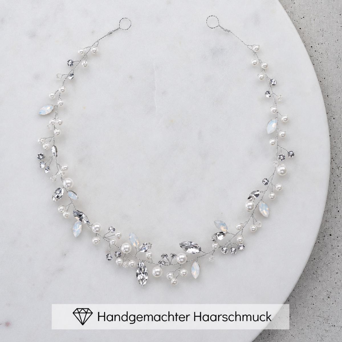 Braut Headpiece Luise in Silber mit Perlen und Kristallen, liegend auf einer Marmorplatte