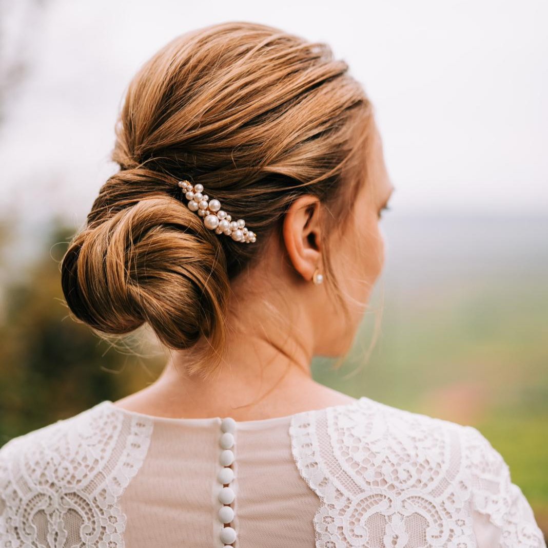 Braut Haarkamm Wilma in Roségold mit unterschiedlich großen, veganen Perlen, getragen in einer eleganten Hochsteckfrisur