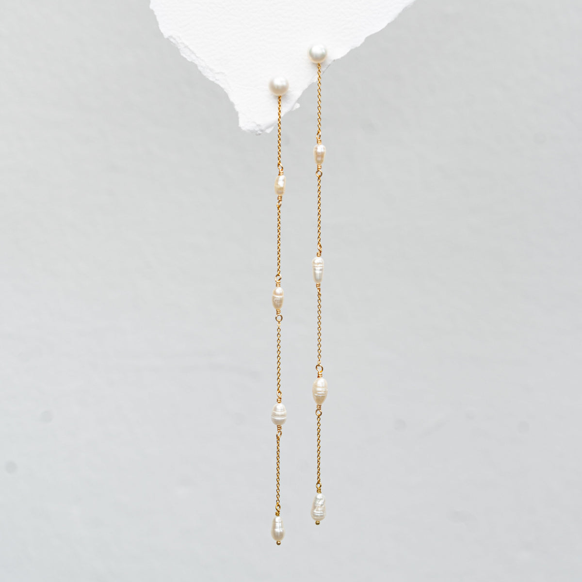 Braut Ohrringe Maeve lang aus 925 Sterlingsilber 18K vergoldet, Perlenstecker mit Süßwasserperlen und zarten Kettchen, in Nahaufnahme