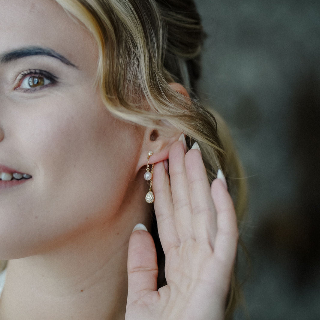 Brautohrringe Elaine in Gold, von einer Braut getragen in Detailaufnahme