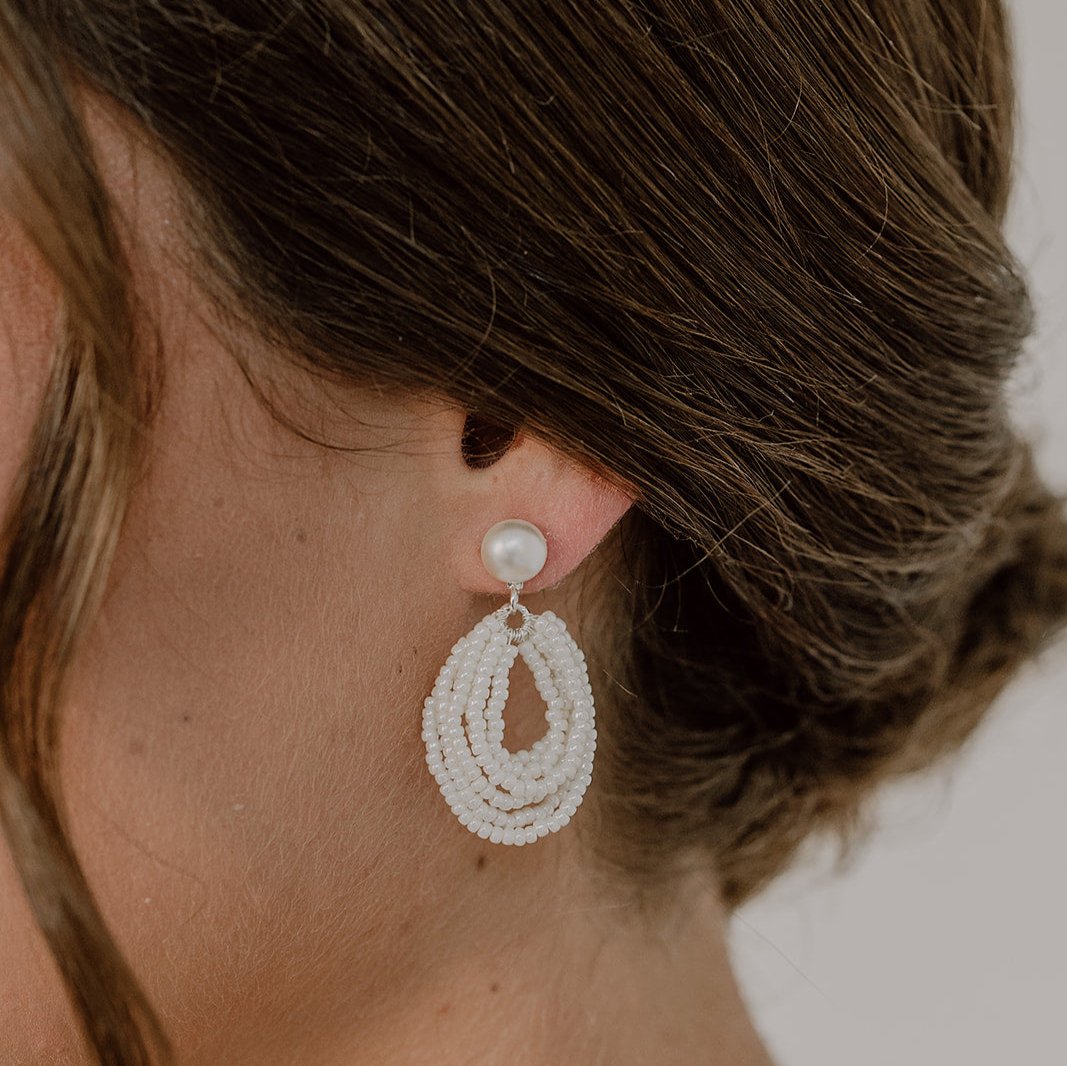 Brautohrringe Gigi aus 925 Sterlingsilber mit Perlenstecker und hängenden, kleinen Perlen in mehrreihiger Tropfenform, am Model getragen in Nahaufnahme
