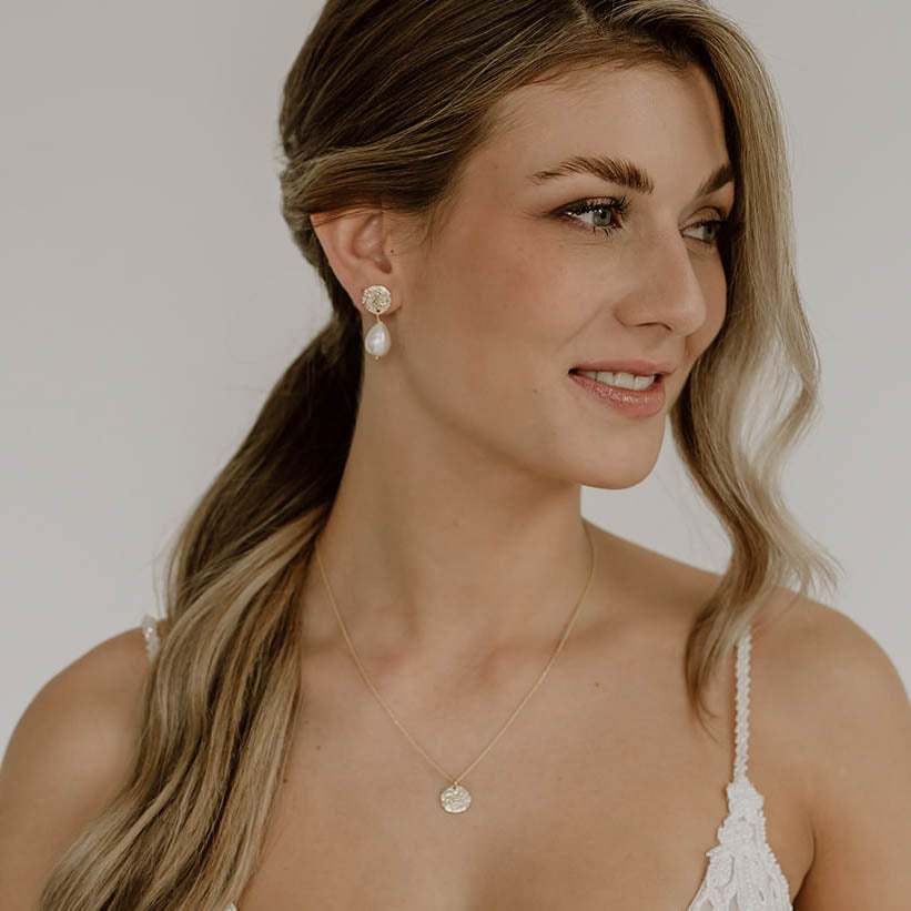 Brautohrringe Johanna aus 925 Sterlingsilber 18K vergoldet mit gehämmerter, runder Platte und tropfenförmiger Süßwasserperle, am Model getragen mit passender Halskette