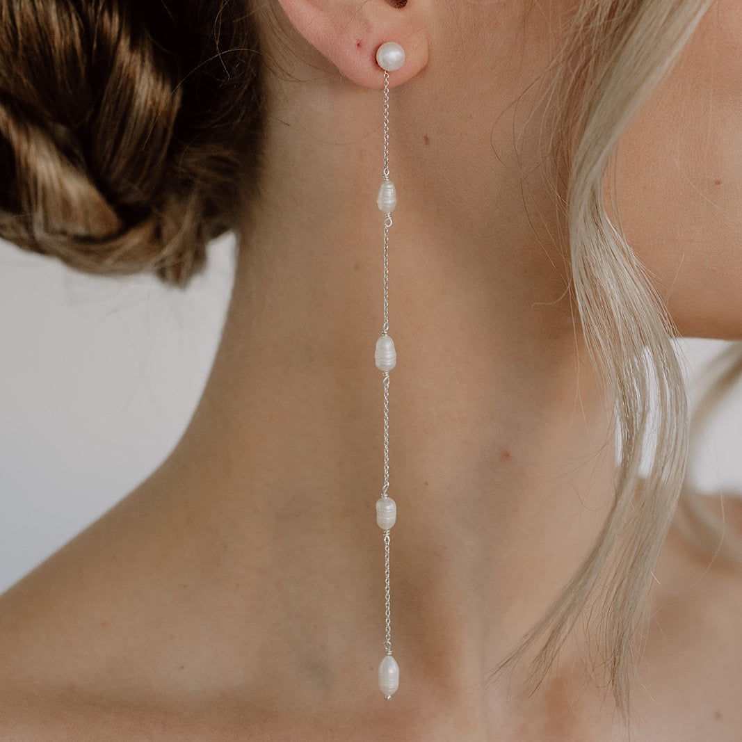 Braut Ohrringe Maeve lang aus 925 Sterlingsilber. Perlenstecker mit Süßwasserperlen und zarten Kettchen, am Model getragen in Nahaufnahme