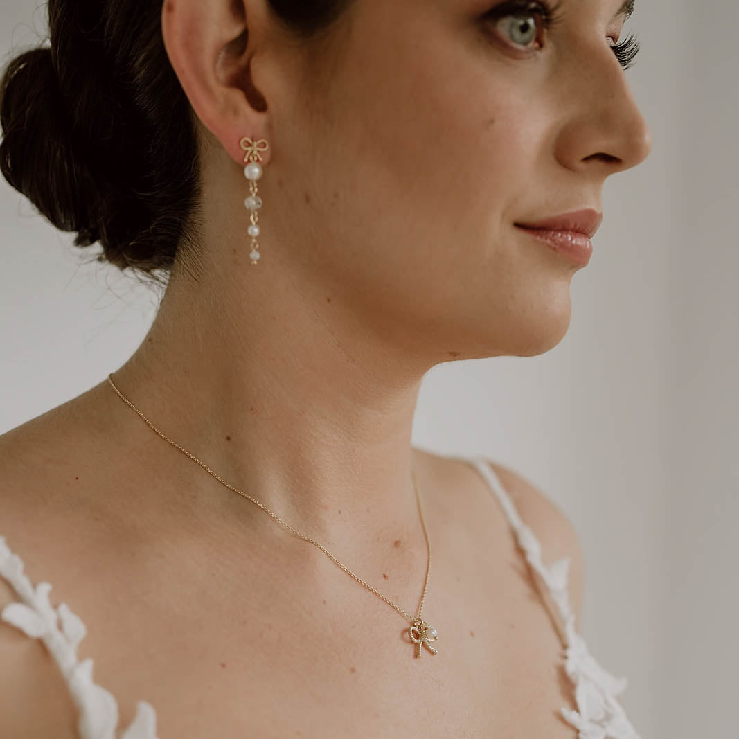 Braut Halskette Pinella aus 925 Sterlingsilber 18K vergoldet mit Schleife und veganer Perle, am Model getragen