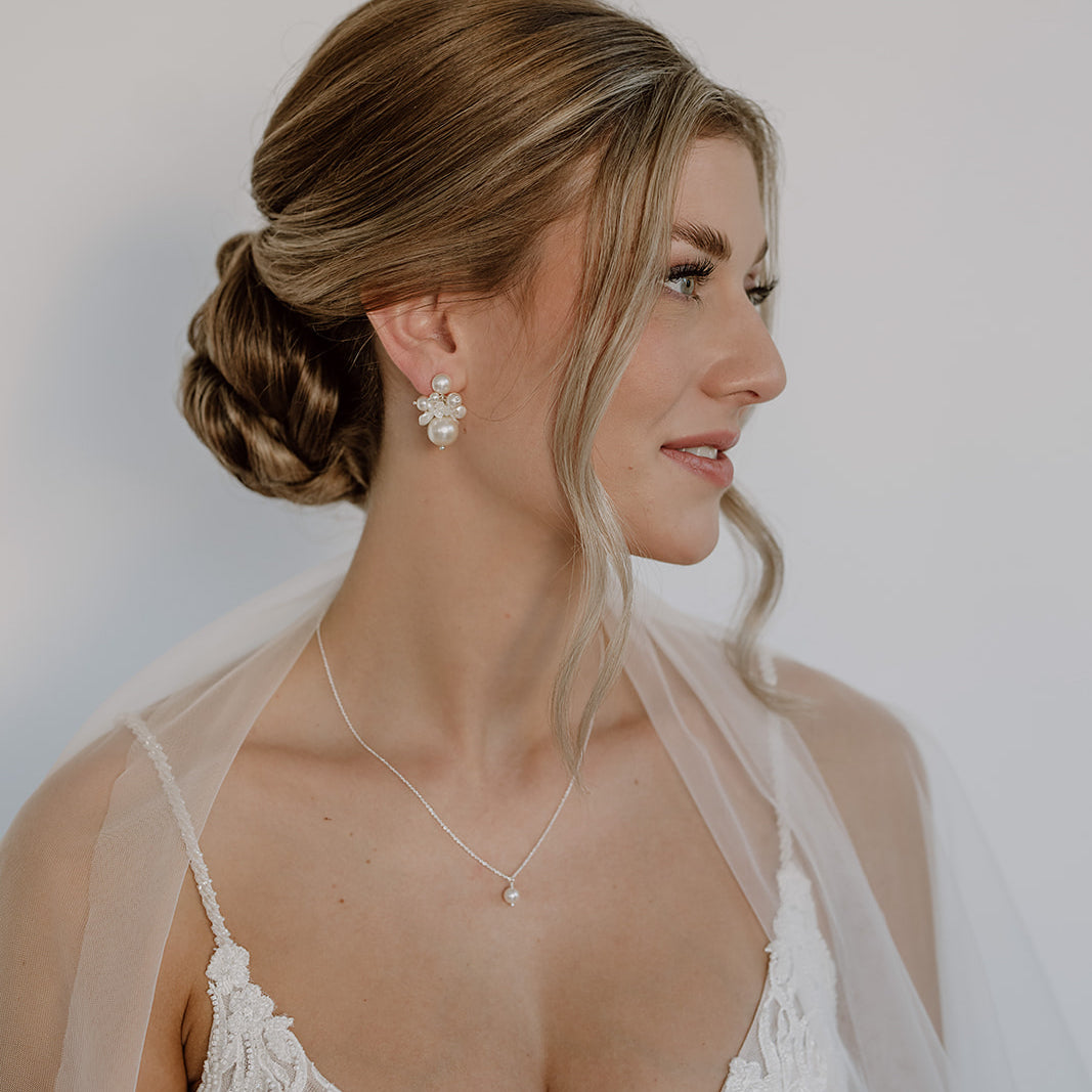 Braut Ohrringe Sofie in 925 Sterlingsilber mit unterschiedlich großen, veganen Perlen und Blüten mit passender Braut Halskette Linda, Nahaufnahme am Ohr