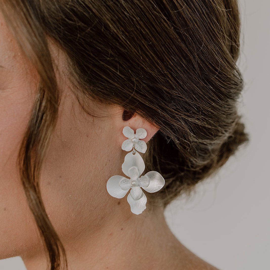 Statement Ohrringe Vika, eine große Blüte hängt an einem kleinen Blütenstecker mit veganen Perlen in 925 Sterlingsilber, in Nahaufnahme am Model